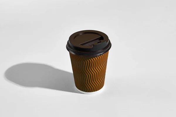 灰色の背景に黒いふた付きの茶色の紙カップのホット コーヒー — ストック写真