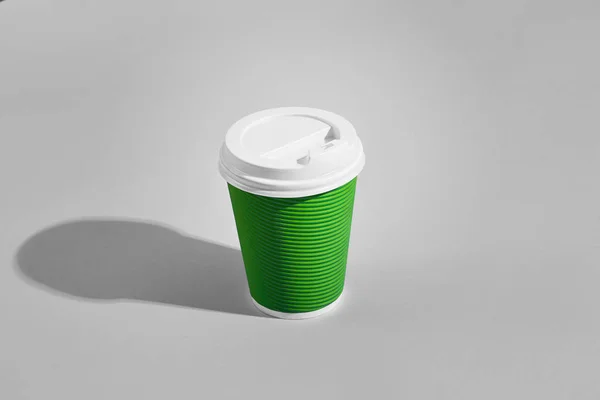 灰色の背景に白い蓋付き緑の紙カップのホット コーヒー — ストック写真