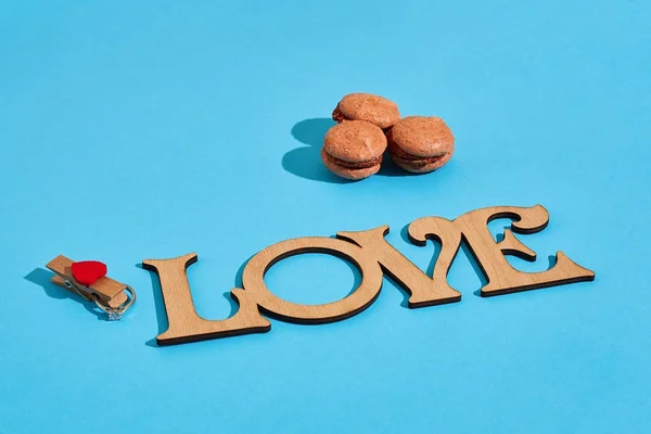 Macaroons em um fundo azul com as palavras que eu amo soletrado i — Fotografia de Stock