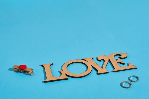 Inscrição de madeira Amor e o anel no fundo azul. Pedido de casamento. O conceito de Dia dos Namorados — Fotografia de Stock
