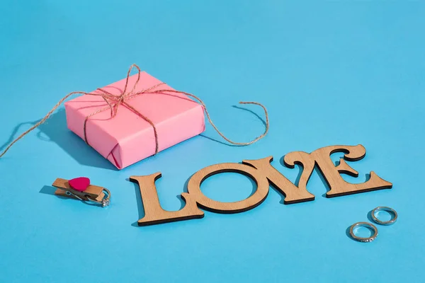 木铭文爱, 礼品盒和蓝色背景戒指。求婚情人节的概念 — 图库照片