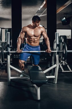 Yakışıklı güç dumbbell ve barbell ile kasları kadar pompalama diyet eğitim spor adamı. Güçlü vücut geliştirmeci, mükemmel abs, omuzlar, pazı, triceps ve göğüs