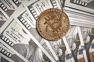 100 dolarlık banknotların üzerinde Bitcoin 'in sembolik sikkeleri. Bitcoin 'i bir dolara değişelim..