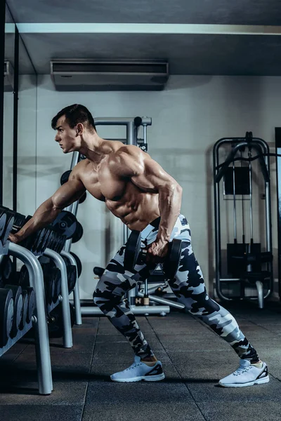 英俊的力量运动的人在节食训练抽肌肉用哑铃和杠铃。强壮的健美运动员, 完美的腹肌, 肩膀, 肱二头肌 — 图库照片