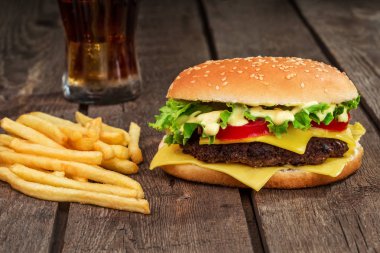 Fast food. Çizburger ve patates kızartması ahşap arka plan üzerinde