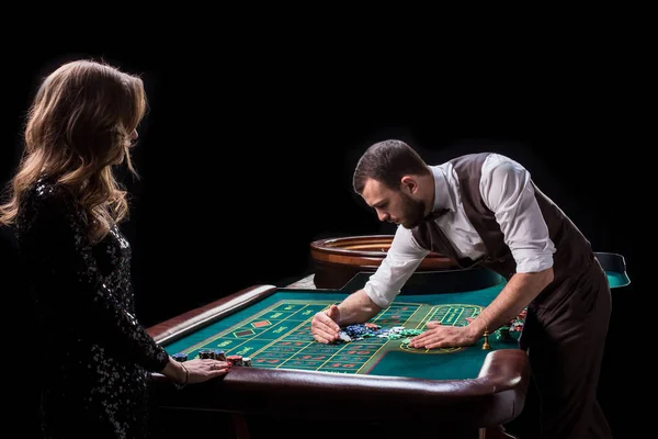 Croupier en vrouw speler aan een tafel in een casino. Foto van een c — Stockfoto