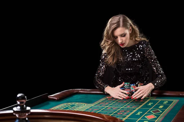 Frau spielt im Casino. Frau setzt stapelweise Chips beim Rou spielen ein — Stockfoto