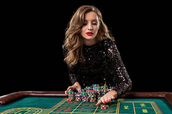 Uma mulher a jogar no casino. Mulher estacas pilhas de chips jogando rou — Fotografia de Stock