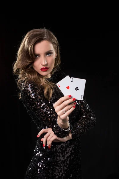 Молодая женщина держит игральные карты на черном фоне — стоковое фото