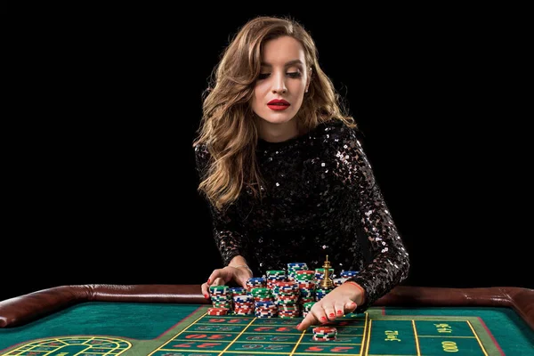 Woman playing in casino. Woman stakes piles of chips playing rou Stock Picture