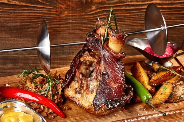 Roasted pork knuckle eisbein with braised boiled cabbage, potatoes, chili peppers and mustard on wooden cutting board — Stock Photo, Image