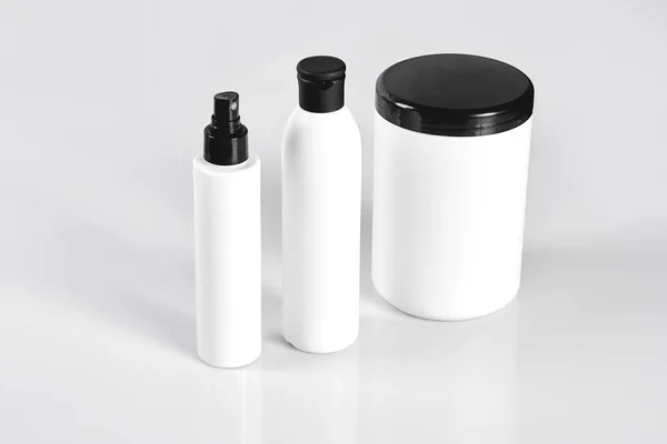 Zestaw kosmetyków w białe pojemniki na jasnym tle. — Zdjęcie stockowe