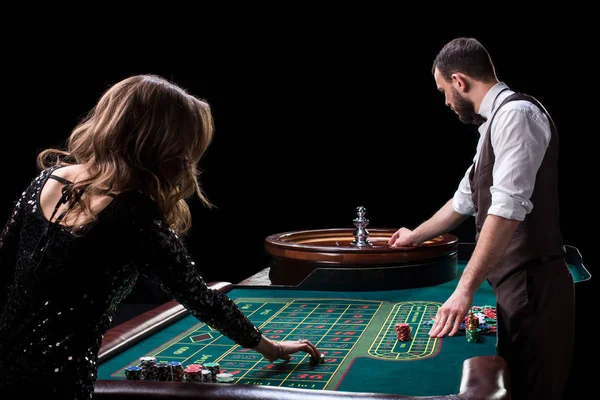 Bir tablo bir casinoda krupiye ve kadın oyuncu. C resmi — Stok fotoğraf