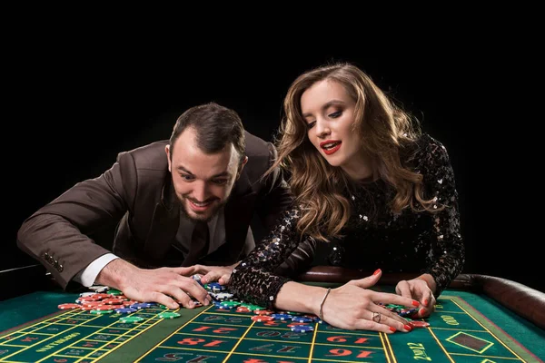 Hombre y mujer jugando en la mesa de ruleta en el casino — Foto de Stock