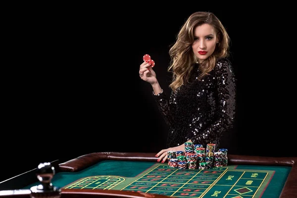 Uma mulher a jogar no casino. Mulher estacas pilhas de chips jogando rou — Fotografia de Stock