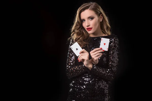 在黑色背景下拿着扑克牌的年轻女子 — 图库照片