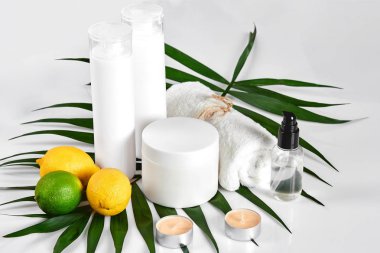 Beyaz şişe ve iki bütün limon ve beyaz arka plan üzerinde izole limon. Kozmetik reklam kavramı