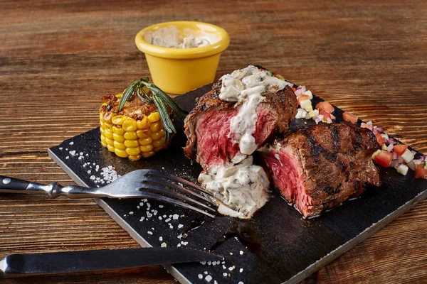 Detail čerstvý Grilovaný hovězí steak s houbovou omáčkou smetana na černé desce na dřevěné pozadí — Stock fotografie
