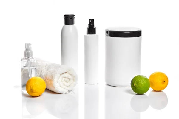 Białe butelki i dwie całe cytryny i limonki na białym tle. Rozwiązanie dla reklamy kosmetyków — Zdjęcie stockowe