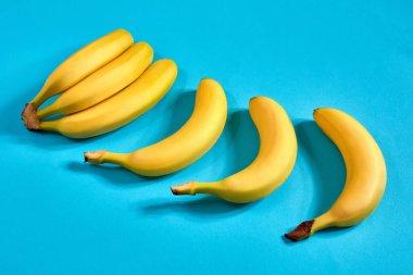 Metin veya tasarım için alan mavi zemin üzerine sarı olgun muz. Üstten Görünüm