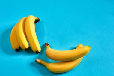 Metin veya tasarım için alan mavi zemin üzerine sarı olgun muz. Üstten Görünüm