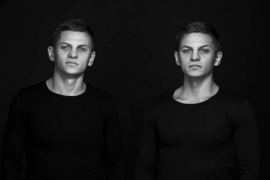 İki çekici olumlu genç kardeşler ayakta giymiş ikiz