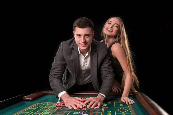 Όμορφο ζευγάρι παίρνει τα κέρδη τους στο τραπέζι της ρουλέτας στο καζίνο — Φωτογραφία Αρχείου