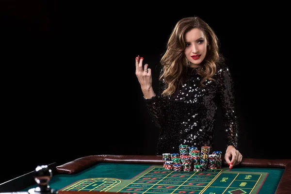 Uma mulher a jogar no casino. Mulher estacas pilhas de chips jogando rou — Fotografia de Stock