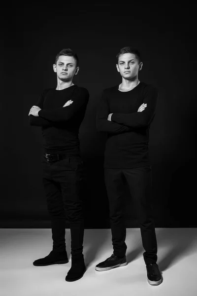 Hermanos gemelos casuales. Grabado en estudio. Fotografía en blanco y negro —  Fotos de Stock