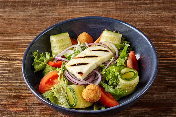 Insalata di tofu fritta con cetrioli, pomodori, avocado e semi di sesamo. Insalata di verdure asiatiche fatte in casa e tofu in ciotola di ceramica su sfondo di legno . — Foto Stock