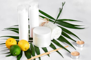 Beyaz şişe ve iki bütün limon ve beyaz arka plan üzerinde izole limon. Kozmetik reklam kavramı