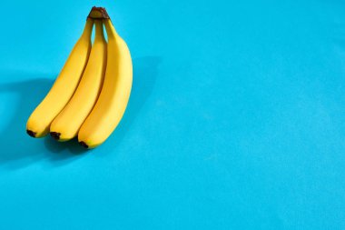 Metin veya tasarım için alan mavi zemin üzerine sarı olgun muz. Üstten Görünüm