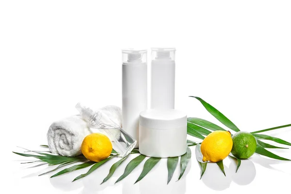 白瓶和两个整体柠檬和石灰隔离在白色背景。广告化妆品的概念 — 图库照片