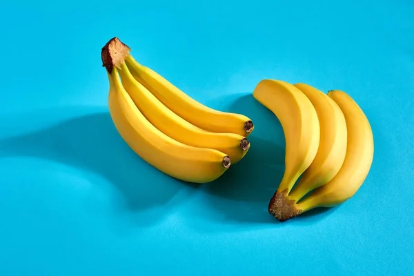Gelbe reife Bananen auf blauem Hintergrund mit Platz für Text oder Design. Ansicht von oben — Stockfoto