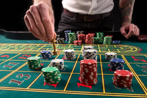 Una imagen vibrante de primer plano de la mesa de casino verde con ruleta, con las manos de croupier y fichas multicolores . —  Fotos de Stock