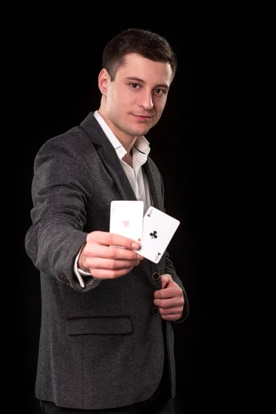 Кавказький юнак носити костюм виявиться два тузи в руці на чорному тлі. Азартні ігри концепції. Казино — стокове фото