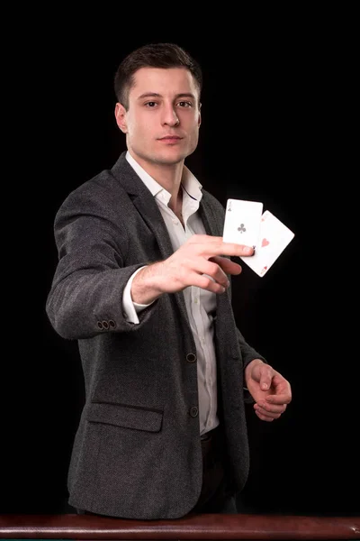 黒の背景に手に 2 つの ace を持ってスーツを着ての若い白人男。ギャンブルのコンセプトです。カジノ — ストック写真