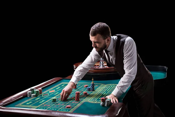 Croupier hinter Spieltisch im Casino. — Stockfoto