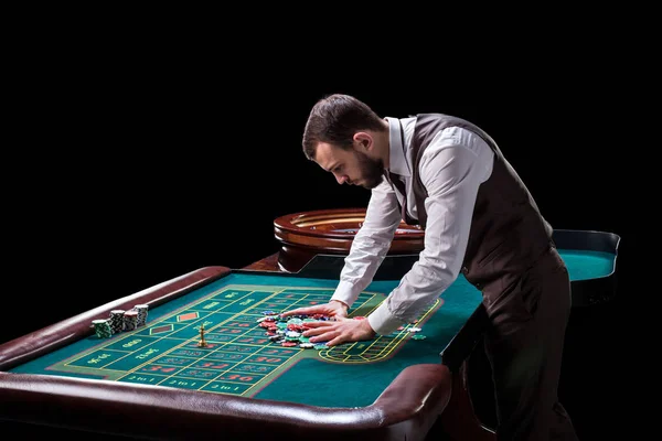 Croupier hinter Spieltisch im Casino. — Stockfoto