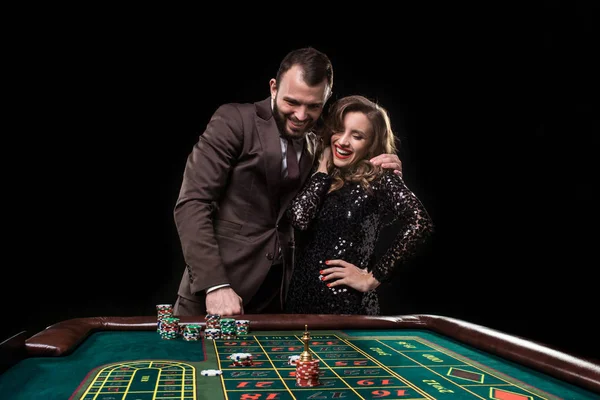 Man and woman playing at roulette table in casino — Stock Photo, Image