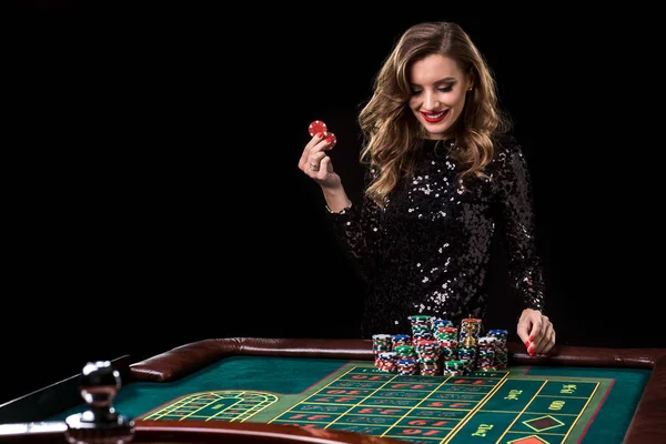 Uma mulher a jogar no casino. Mulher estacas pilhas de chips jogando rou — Fotografia de Stock