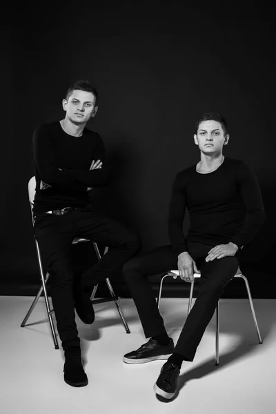 Hermanos gemelos casuales. Grabado en estudio. Fotografía en blanco y negro —  Fotos de Stock