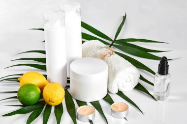 Beyaz şişe ve iki bütün limon ve beyaz arka plan üzerinde izole limon. Kozmetik reklam kavramı