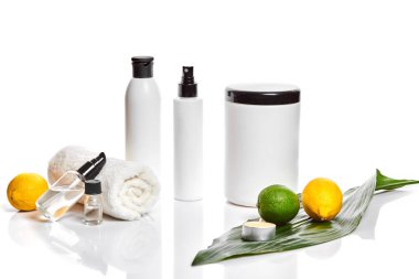 Beyaz şişe ve iki bütün limon ve beyaz arka plan üzerinde izole limon. Kozmetik reklam kavramı