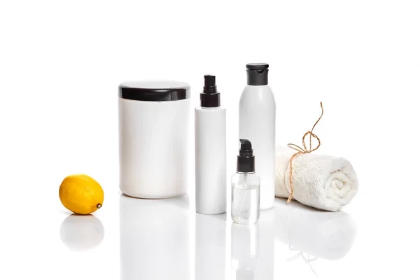 White bottles and one whole lemon isolated on white background. The concept for advertising cosmetics — Stock Photo, Image