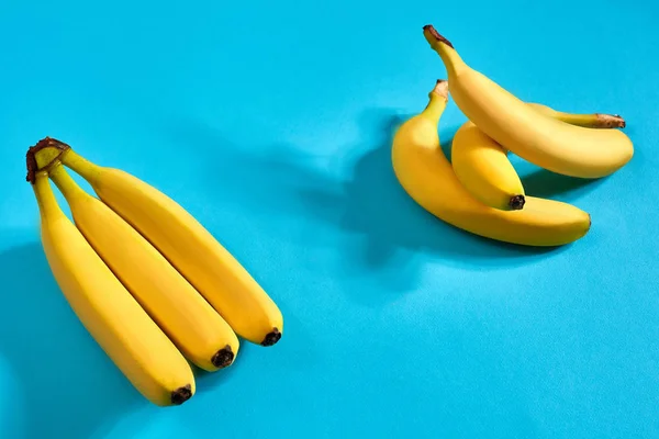 Frische Bananen aus nächster Nähe auf hellblauem Hintergrund. flach lag. Sommerkonzept. — Stockfoto