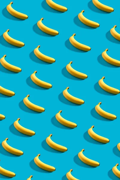 Buntes Muster von Bananen auf himmelblauem Hintergrund. — Stockfoto