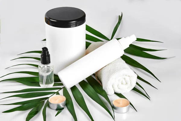 Produits cosmétiques blancs et feuilles vertes sur fond blanc. Produits de beauté naturels pour le concept de maquette de marque . — Photo