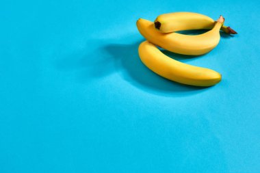 Taze muz parlak mavi zemin üzerine kapatın. Düz yatıyordu. Yaz konsepti.