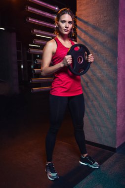 Kız atlet tutar disk bardan crossfit ve fitness yapmak için ağırlık Ajan.
